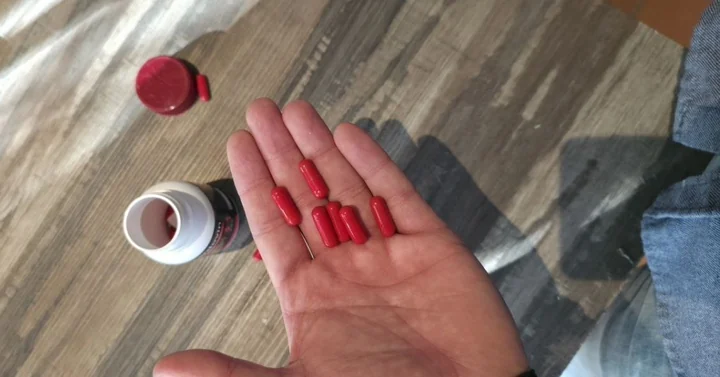 Red Cardovin capsules in an open palm